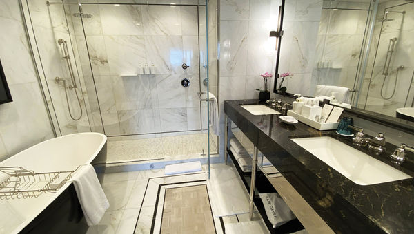 Bathrooms include spacious rainfall showers, with higher-end accommodations also including soaking tubs.