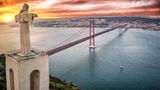 The Cristo Rei statue overlooking Lisbon from 25 Abril Bridge in Almada, Portugal.