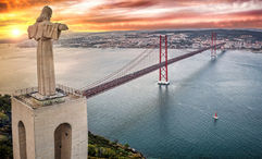 The Cristo Rei statue overlooking Lisbon from 25 Abril Bridge in Almada, Portugal.