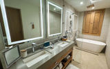 The spacious bathroom, including an oversized tub, in a beachfront one-bedroom villa suite.